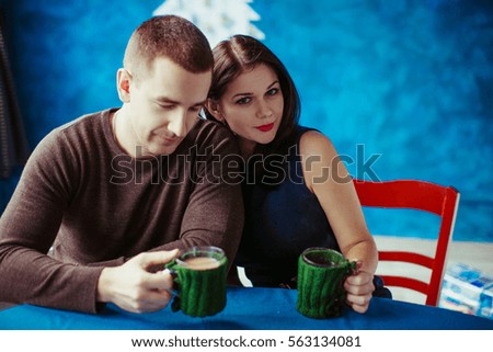 Man and woman drinking cocoa on the blue background