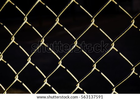 Wire Mesh on sunlight in front of black wall 