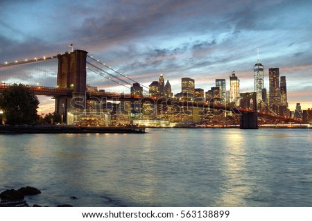 Silhouette of Manhattan skyline with Brooklyn Bridge at sunset.