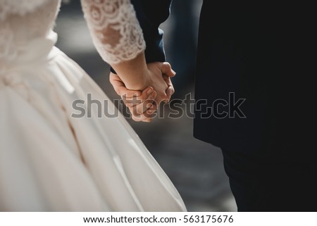 The lovely couple in love hold of hands Royalty-Free Stock Photo #563175676