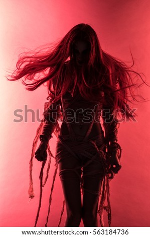 Silhouette of young mummy woman in bandage on pink background