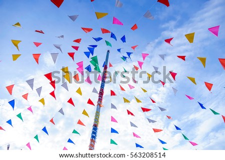 vivid color of Thai's style fancy party flag strips decoration on a fancy still pole with blue sky and white cloud in background