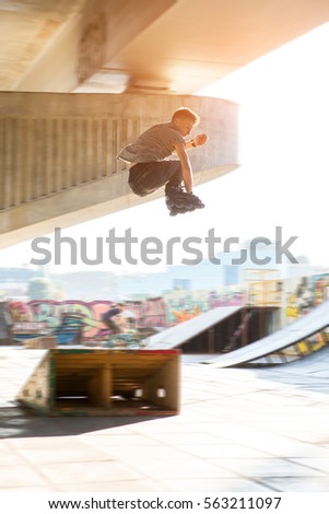 Guy on rollerblades jumping. Young man rollerblading outdoors. Jump off the ramp.
