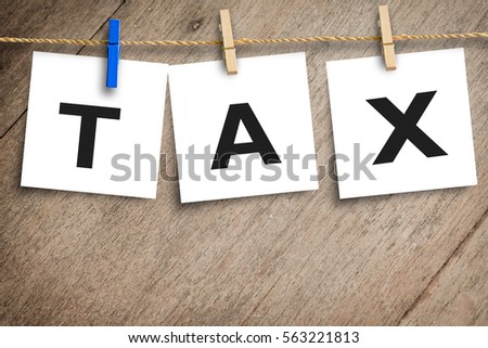 Tax message on placard paper hanging with wooden background