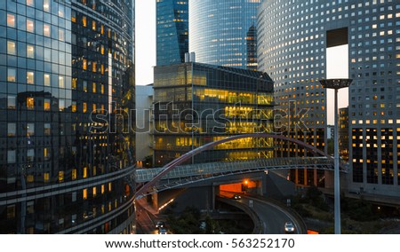 Night architecture - skyscrapers with glass facade. Modern buildings in Paris business district. Evening dynamic traffic on a street. Concept of economics, financial.  Copy space for text. Toned