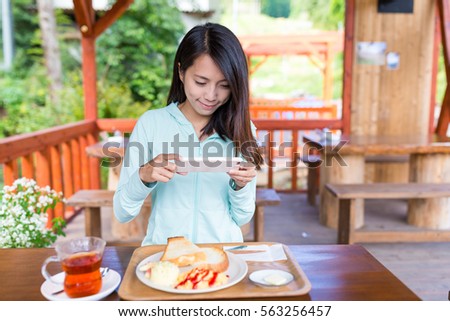 Woman taking photo before on her breakfast