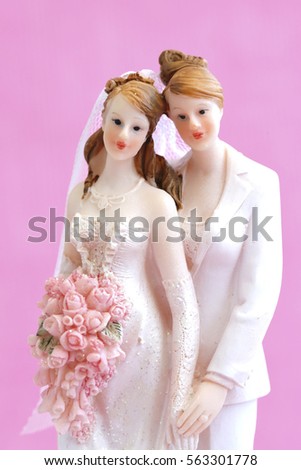 A lesbian couple against a pink background