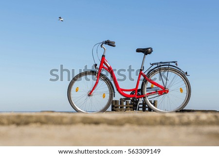 Lonely bicycle on the beach on sand with sky and calm sea at background
