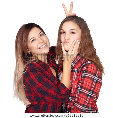 Attractive sisters goofing around and smiling at the camera. White background.