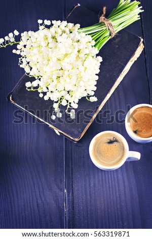 Two cups of coffee - espresso and bouquet of flowers - lilies of the valley on black background. romantic breakfast for my birthday, Valentine's Day.