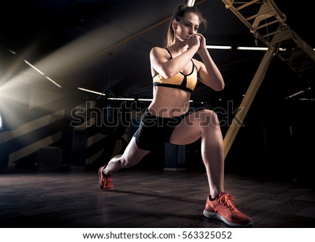 Sportive young woman in a gym training. Working out in a fitness gym. Royalty-Free Stock Photo #563325052
