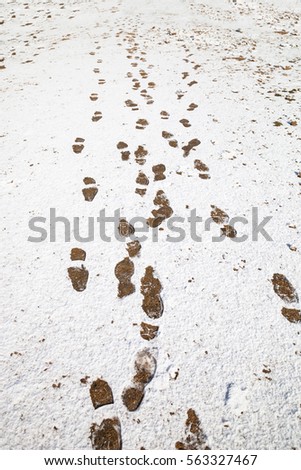 winter background with foot steps on snow ground.