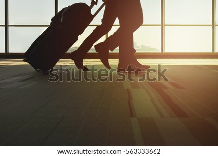 Silhouette traveler with luggage walking in the airport