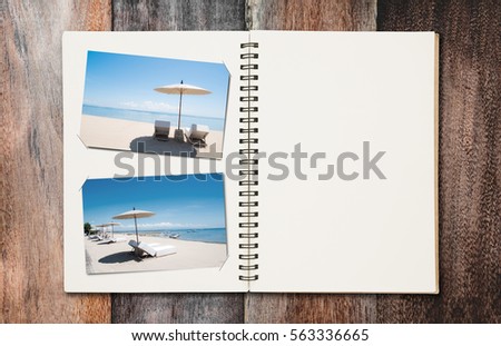 Opened summer holiday journey photo book with copy space, on wooden desk