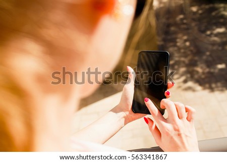 Look over lady's shoulder at iPhone in her elegant hands