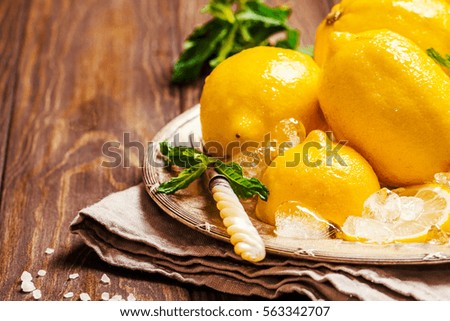Fresh slice lemon with ice on metal tray over the dark wooden table