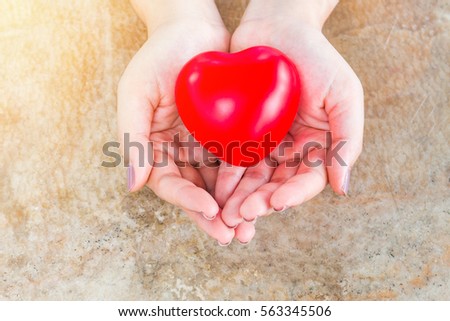 health concept , close up of men hands with small red heart