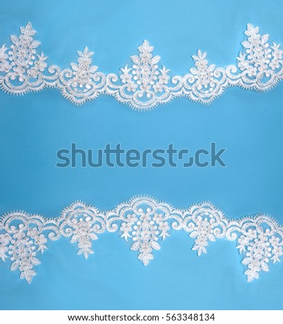 Invitation, greeting or wedding card with white lace on blue background.