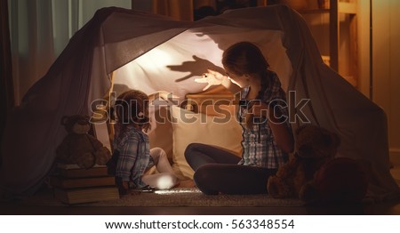 mother scares child daughter tells scary stories, plays in the theater of shadows
 Royalty-Free Stock Photo #563348554