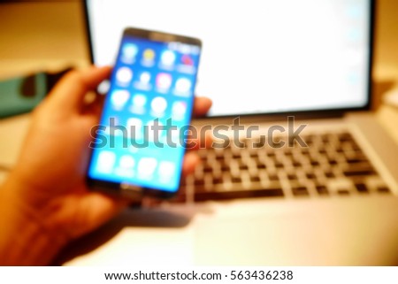Picture blurred  for background abstract and can be illustration to article of hands using smart phone connecting to laptop