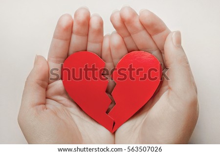 Close up of paper broken heart on white wooden background Royalty-Free Stock Photo #563507026