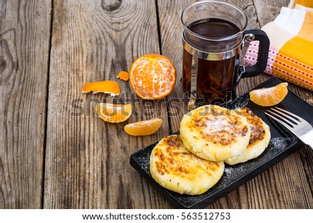 Hot sweet cheesecakes with tangerines and honey. Studio Photo