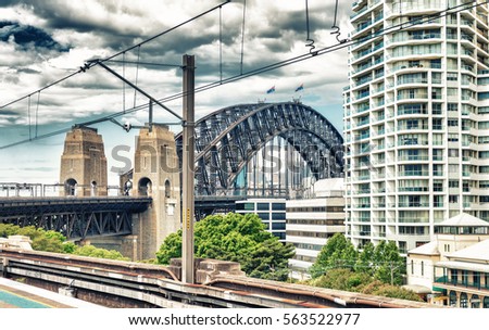 Sydney Harbour Bridge and city buildings along railway.