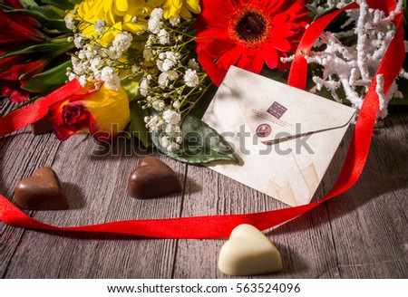 Valentine's Day greeting card, flowers and chocolates on the wooden background