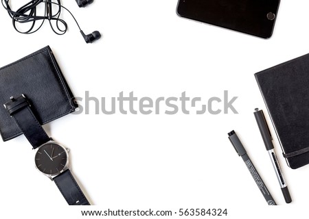 Man Items in all Black on a White Background Shot from Above with Cell Phone, Pens, Wallet, Watch, Notebook, and Headphones
