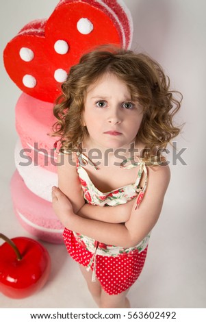 girl in shirt and short shorts standing with a surprised expression with her arms crossed next to the huge biscuits and heart