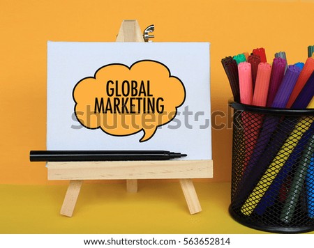 GLOBAL MARKETING - Concept of text at canvas with stand and basket pen on wooden table