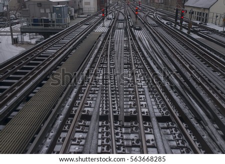 A photograph of Chicago train tracks that are lightly dusted with snow. 