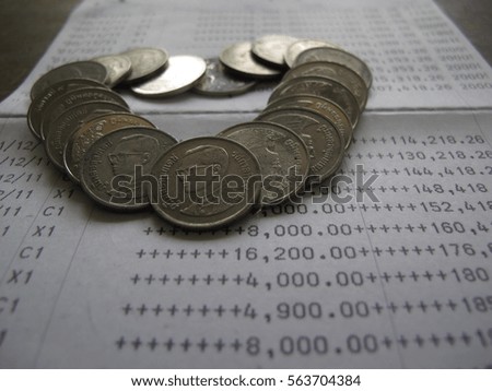 Coin in heart shape on bank statement, love and saving for future concept