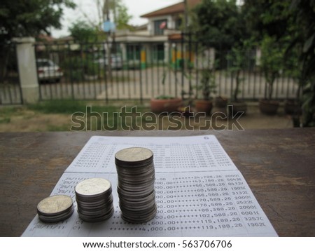 Coin stack on bank statement with house property background, saving for future, property investment, house buying, house rental concept