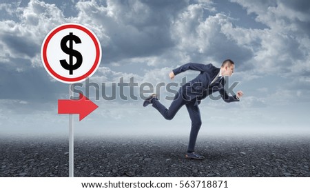 Businessman running on the asphalt and road sign with the dollar sign. Business development. Make profits. Rise in profitability.