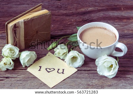 Coffee cup with spring flower lisianthus and notes I love you on wooden table