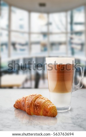 Morning coffee with croissant on marble table.