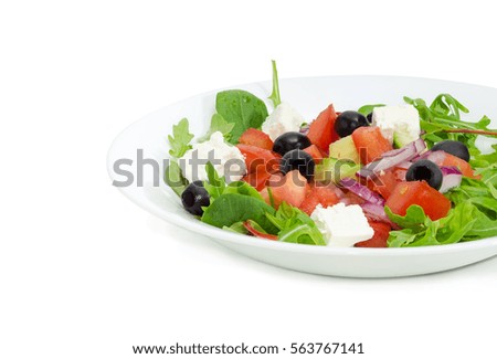 Fragment of a white dish with Greek salad on a light background
