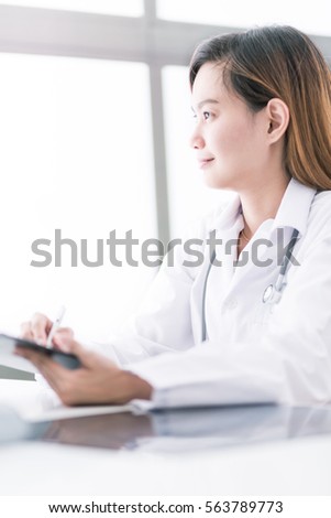 Portrait of a smiling physician working in her office. Asia
