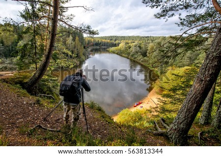 Photographer on the cliff take landscape picture.