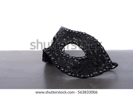 Black mask on wooden table border isolated on white background with copy space