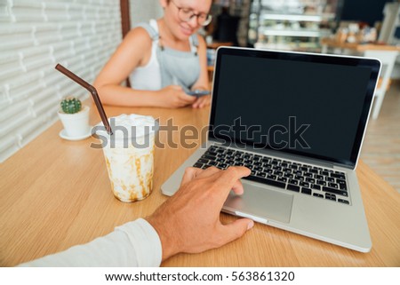 search for information on the Internet. The guy and the girl in the cafe work behind the laptop.
