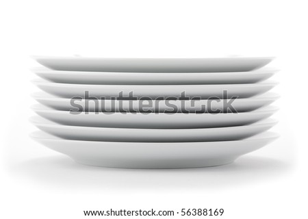 Stacked white dishes on seamless white background.