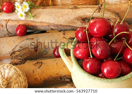 Ripe organic homegrown sweet cherry in ceramic bowl against background branches