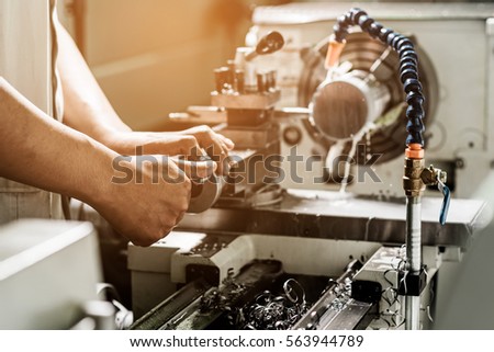 Technicians are turning lathe with horizontal lathe machine. Royalty-Free Stock Photo #563944789