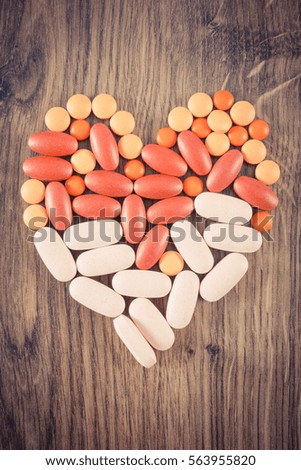 Vintage photo, Heart shaped colorful medical pills, tablets, capsules or supplements for therapy, concept of treatment and health care