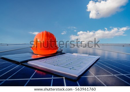 A orange safety cap and check chart on the solar cell board. Royalty-Free Stock Photo #563961760