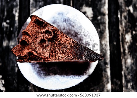 Blurred and Soft picture. Delicious chocolate cake on wooden plate on wooden table