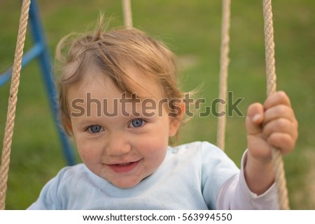 Little cute child smiling and having fun on swing, Czech republic