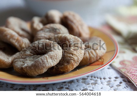 Dried figs on the plate with colorful napkins on the table. 